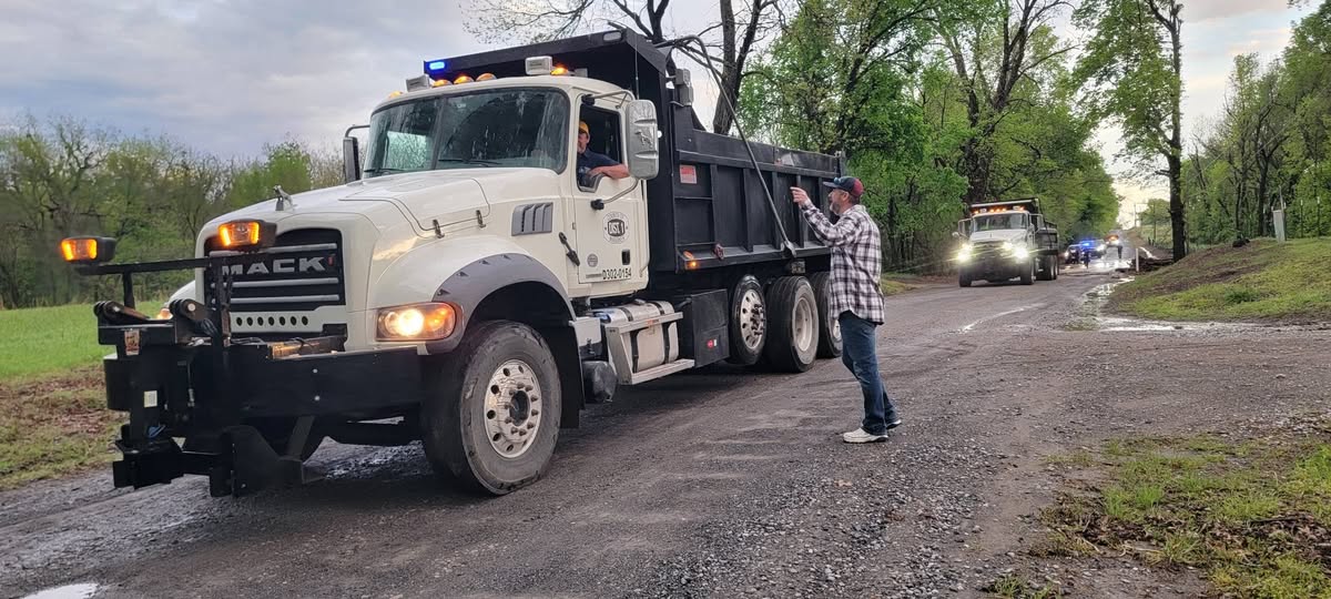 Commissioner Hanning directing a Mack dump truck on a District 1 road project